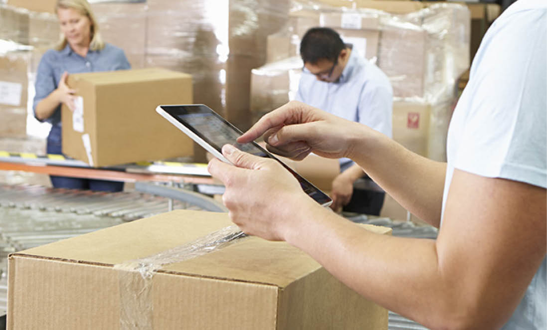 Worker Using Tablet Computer In Distribution Warehouse