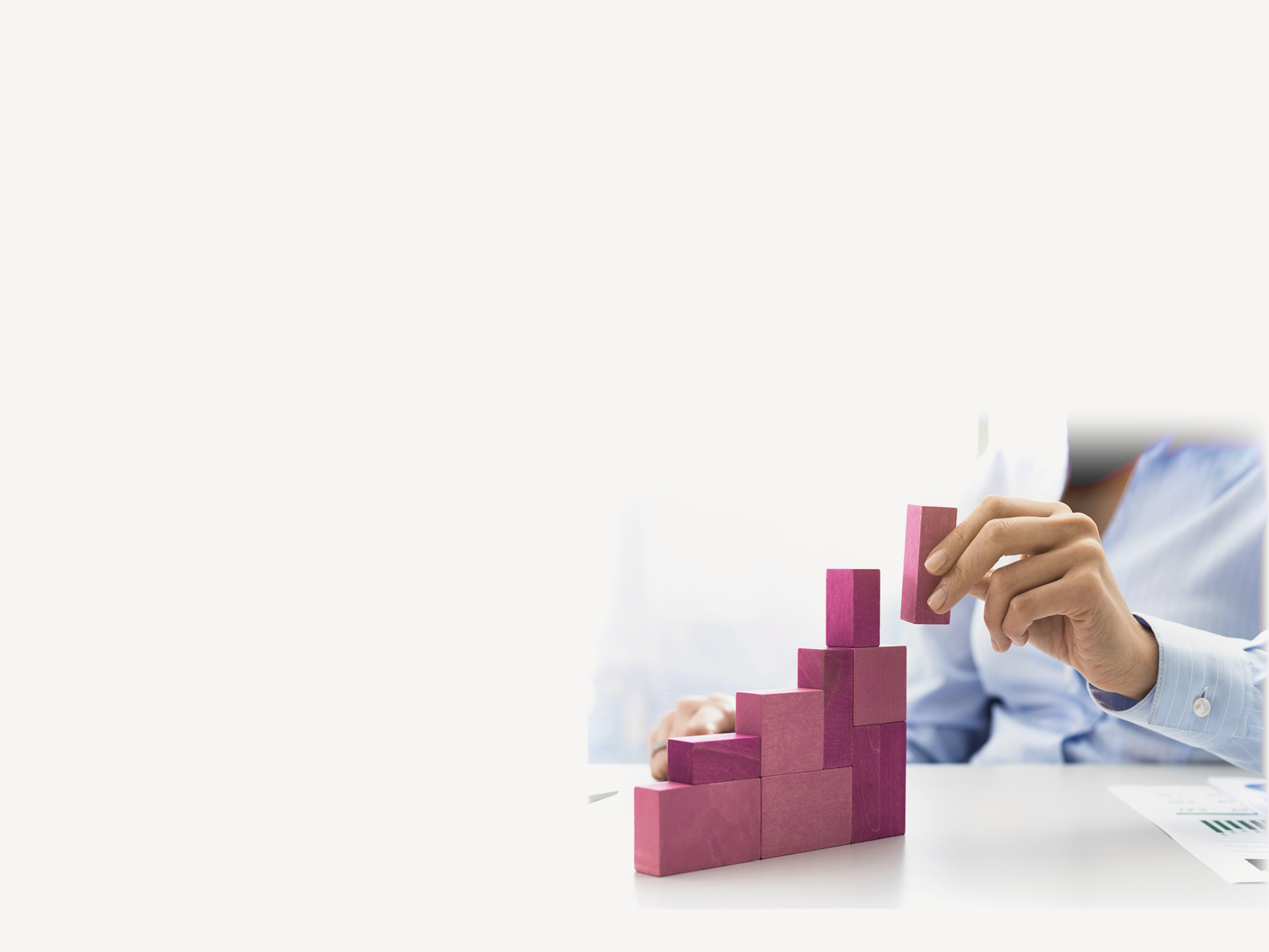 Businesswoman building a growing financial chart with wooden pieces, she is adding the last block, development and strategy concept