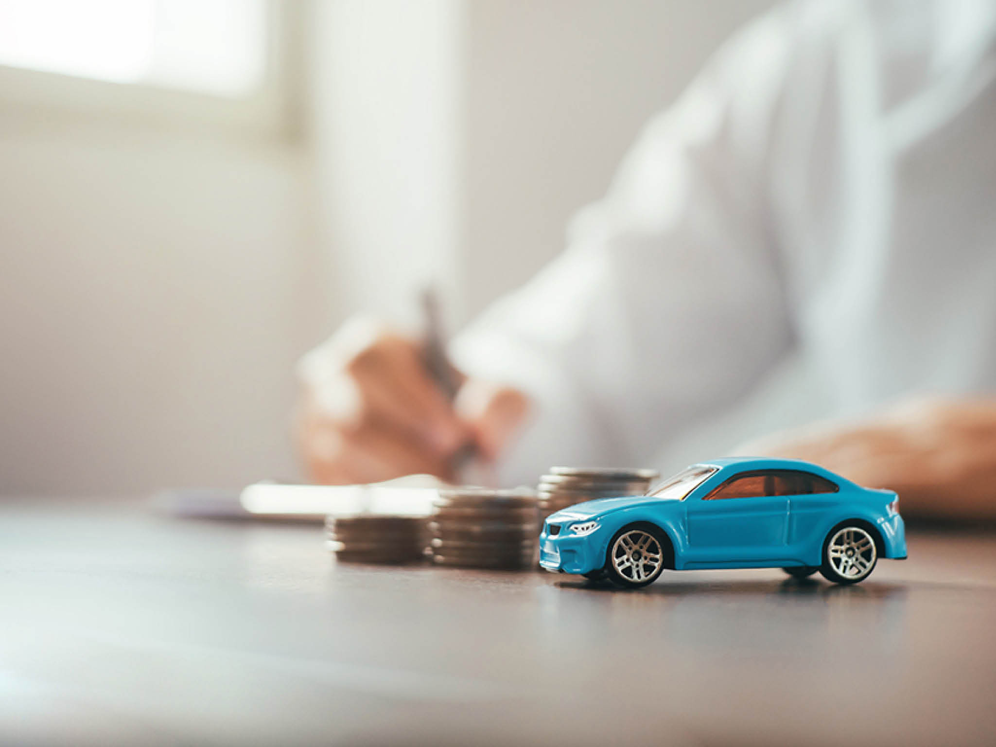 Auto dealer businessman signing auto insurance documents, writing signature on contract or agreement. Buying or selling a new or used car, warranty, new car, bank, customer or salesperson.