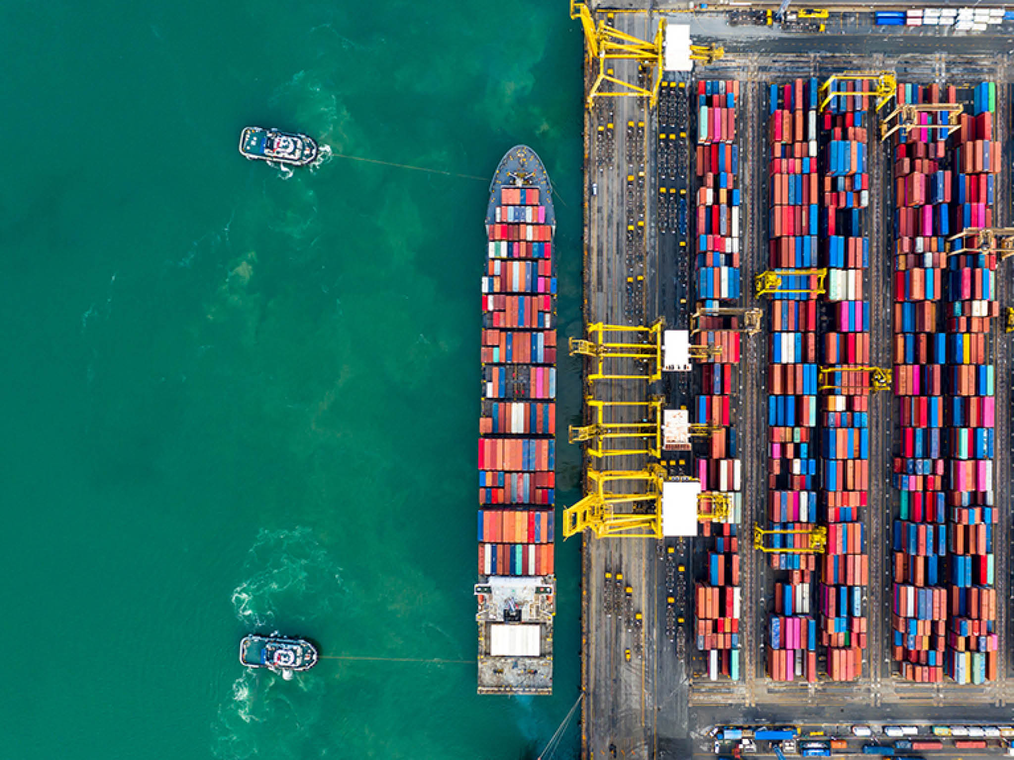 Aerial view tugboats assisting container ship to international commercial dock, Global business import export logistic and transportation company, Commercial dock container cargo vessel freight shipping worldwide.