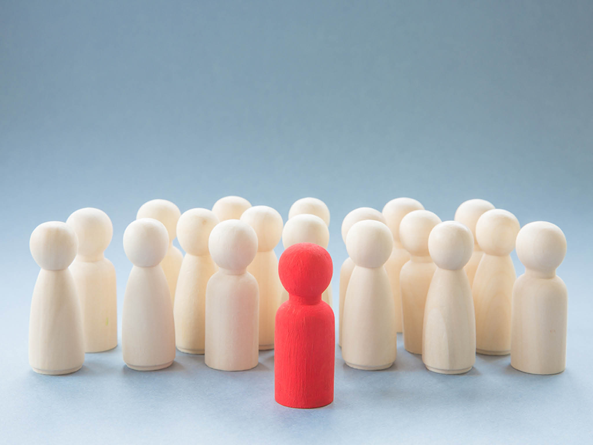 A concept image of a person standing out from a crowd as a leader or inspirational teacher amongst men and women